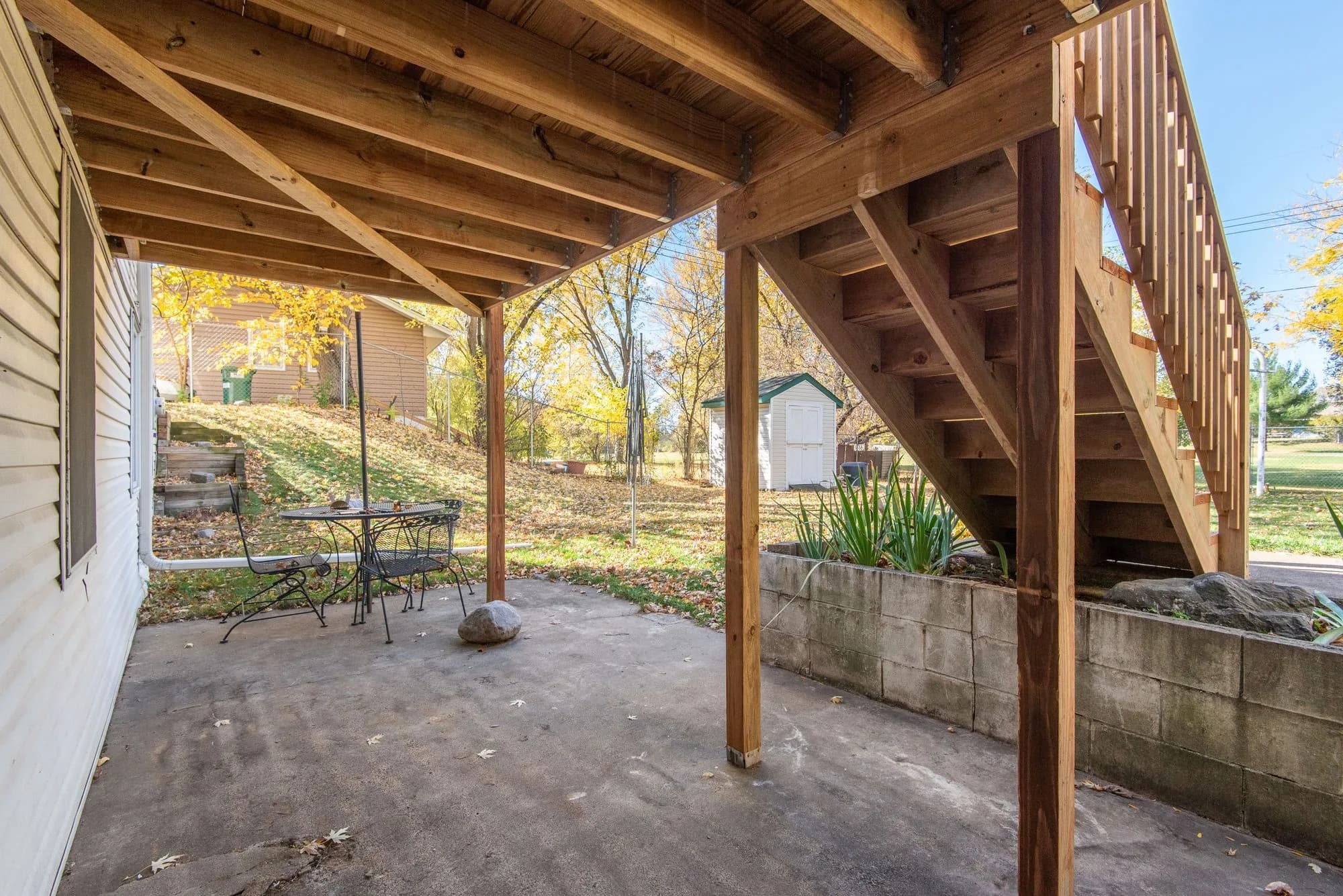 Wooden deck stairs descending to a backyard patio, the kind of layout a deck stair calculator helps you plan before cutting stringers